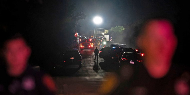 A first responder walks through the scene where dozens of migrants were found dead in an abandoned tractor-trailer outside San Antonio on June 27, 2022.