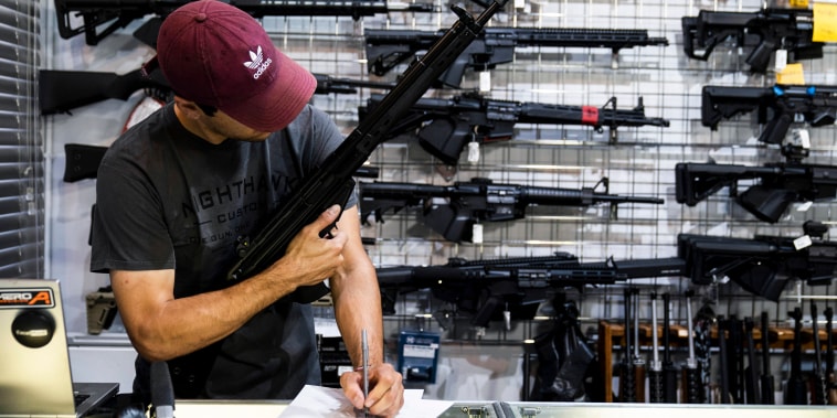 Image: A sales associate fills out an invoice to finalize the sale of a rifle in Burbank, Calif. on June 23, 2022.