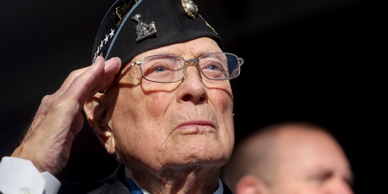 The World War II veteran and recipient of the Medal of Honor salutes the flag during the national anthem at the groundbreaking ceremony for the National Medal of Honor Museum in March 25, 2022 in Arlington, Texas.