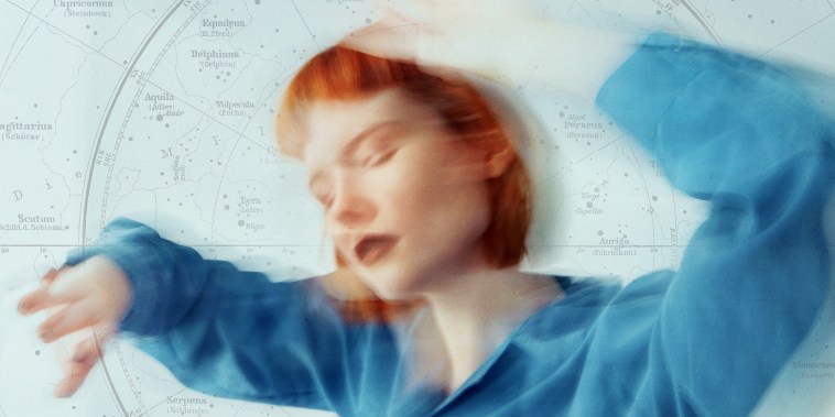 Red haired woman in blue shirt dancing, blurred motion - long exposure