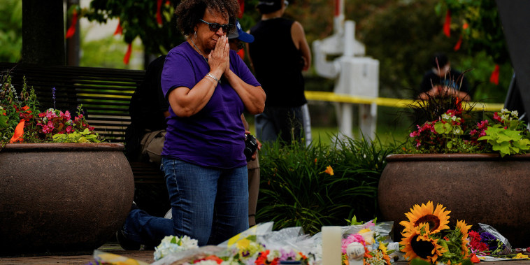 Una mujer reza en un sitio conmemorativo armado tras el tiroteo masivo en el suburbio de Chicago de Highland Park, Illinois.