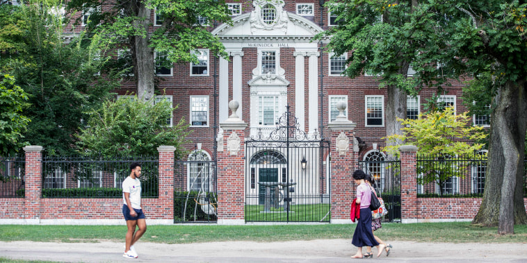 Pedestrians walk past a Harvard University building on Aug. 30, 2018, in Cambridge, Mass.
