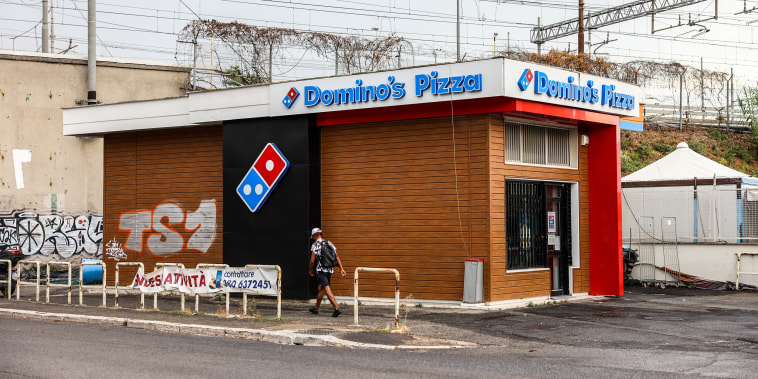 A "For Sale" banner is posted outside a closed-down Domino's Pizza store in Rome, Italy, on Aug. 9, 2022.