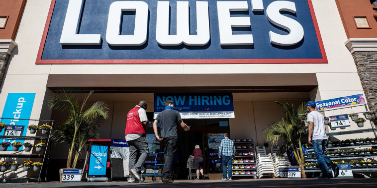 People walk towards the entrance of a Lowe's store
