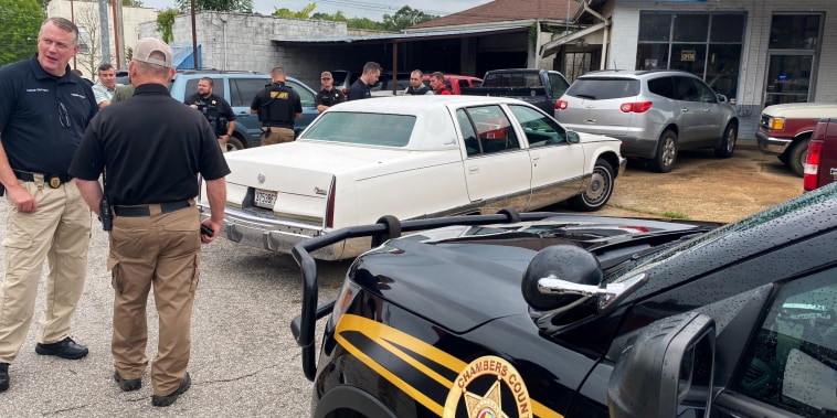 Officers surround a white Cadillac after a man was arrested in La Grange, Ga., on Aug. 17, 2022.
