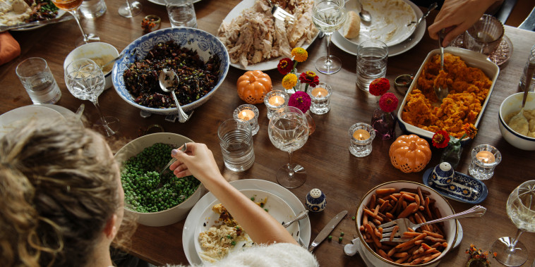 Teenage girl having food while sitting at dining table during Thanksgiving.