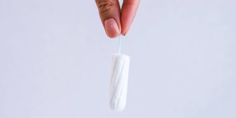 Woman's hand holding clean cotton tampon close-up. Young woman preparing menstruation time. Soft tender protection woman critical days, gynecological. Medical hygiene conception and protection