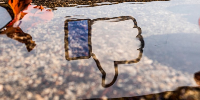 The Facebook logo reflected in a puddle at the company's headquarters in Menlo Park, Calif., on Oct. 25, 2021.