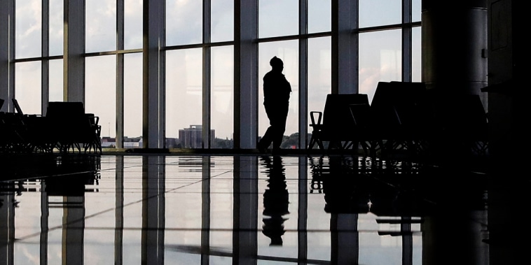 A woman looks through a window at a near-empty terminal at an airport in Atlanta on June 1, 2020.