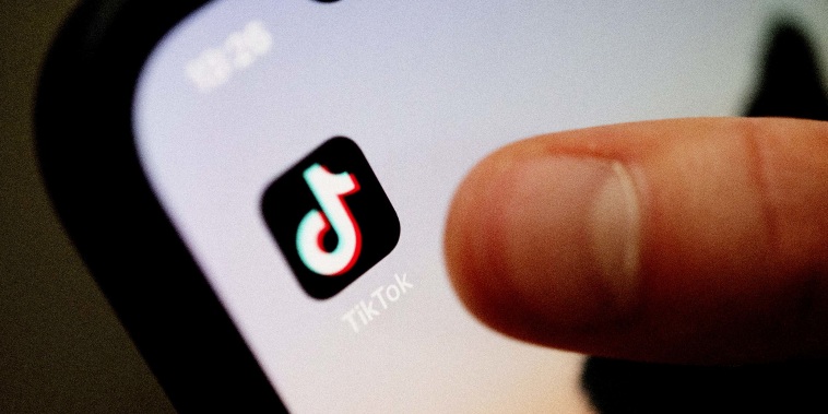 A teenager taps the TikTok app on a smartphone.