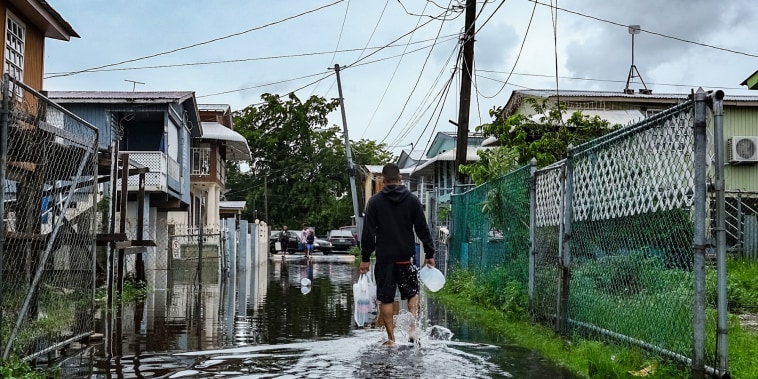 A man walks down a flooded street