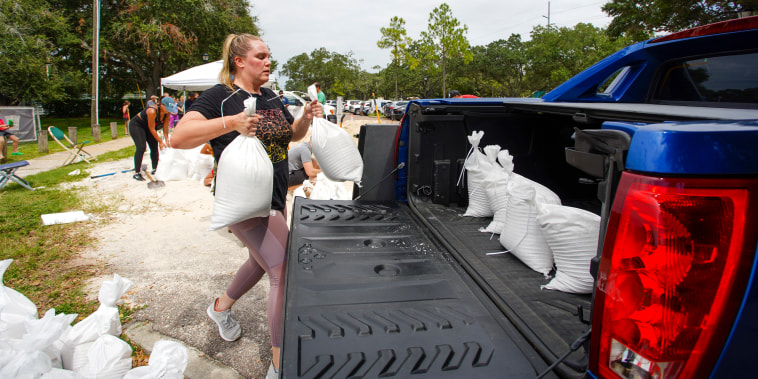 Victoria Colson, de 31 años, de Tampa, carga sacos terreros en su camioneta junto con otros residentes que esperaron unas dos horas en el Complejo Himes Avenue para llevarse sus 10 sacos gratuitos, el domingo 25 de septiembre de 2022 en Tampa, Florida.