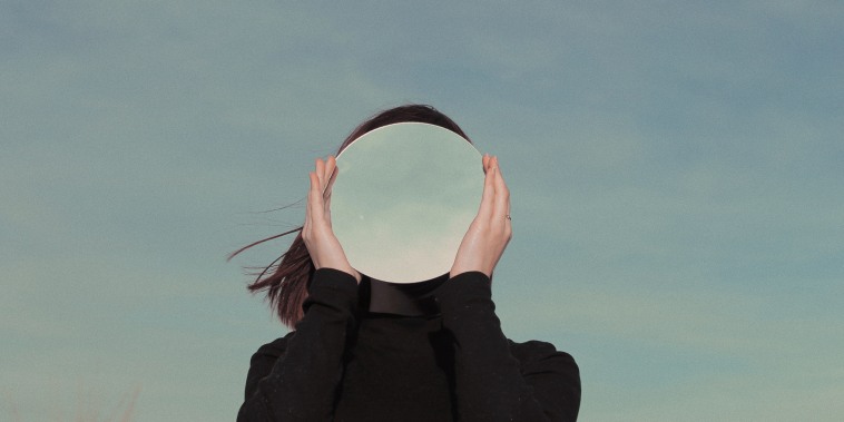 Woman Holding Mirror Against Sky
