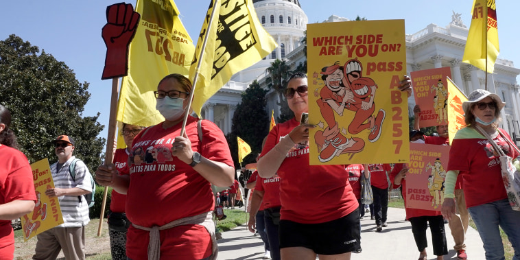 FILE - Fast food workers and their supporters march past the state Capitol calling on passage of a bill to provide increased power to fast-food workers, in Sacramento, Calif., Tuesday, Aug. 16, 2022. California lawmakers adjourned this year's legislative session, Wednesday Aug. 31, 2022, leaving Gov. Gavin Newsom with 30 days to sign or reject hundreds of bills including a bill to give a half-million fast food workers more power, protections and wages. (AP Photo/Rich Pedroncelli, File)