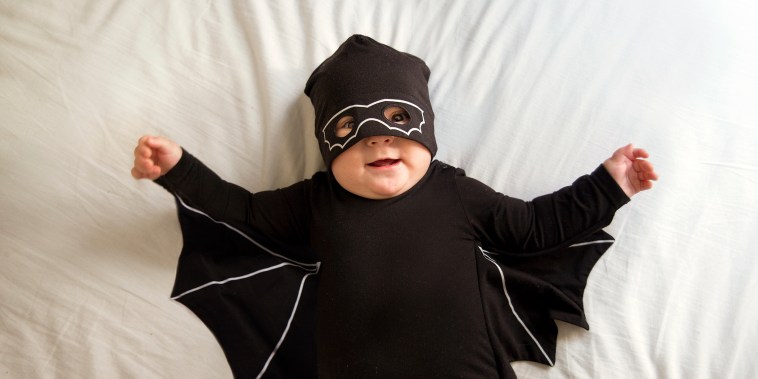 Baby boy dressed as a bat and wearing a mask