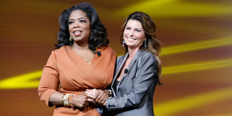 Oprah Winfrey (L) and singer Shania Twain (R) promote OWN on stage