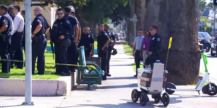A robot rolls past police staged outside Hollywood High School in Los Angeles.