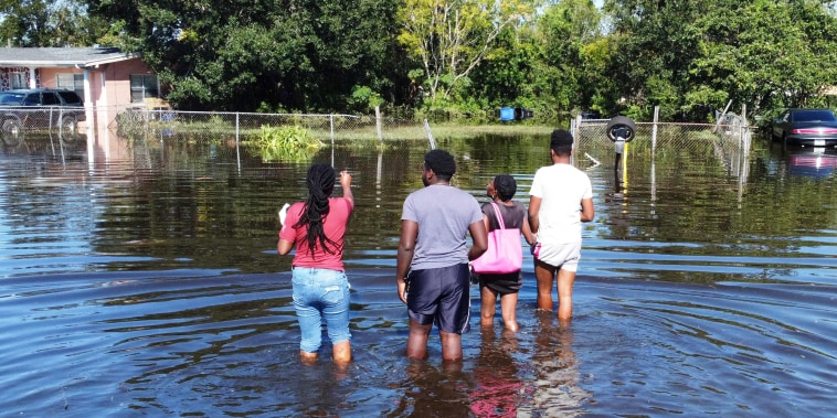 Residents wade through water to get to their house in Orlando