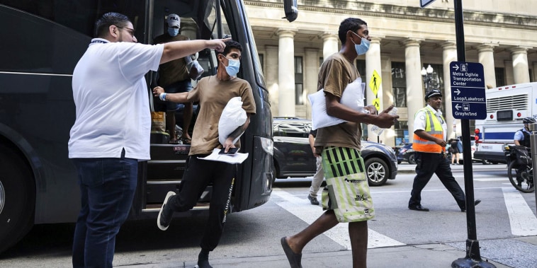 Migrants are led from one bus to another after arriving from Texas at Union Station on Sept. 9, 2022, in Chicago.
