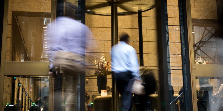 People enter an office building in New York City.