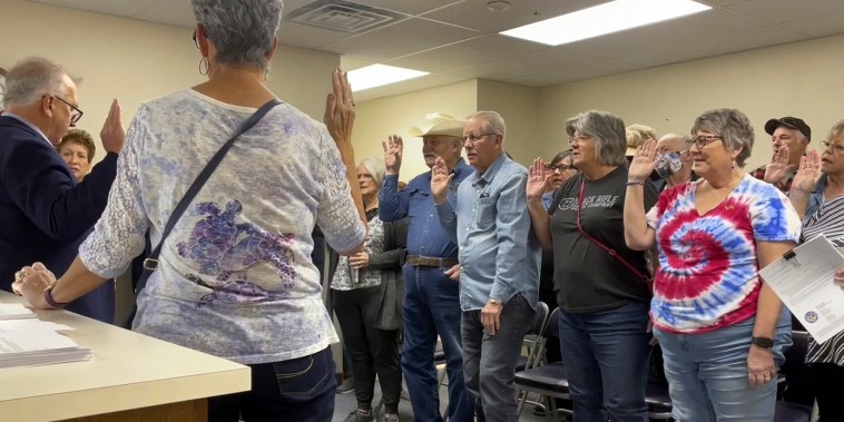 Nye County Clerk Mark Kampf, left, in suit, swears in a group of residents who will hand count early ballots on Oct. 26, 2022, in Pahrump, Nev. 