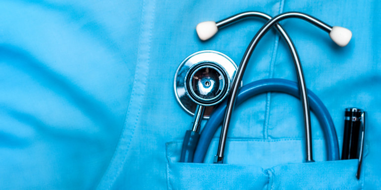 Stethoscope and pen in doctor robe pocket.