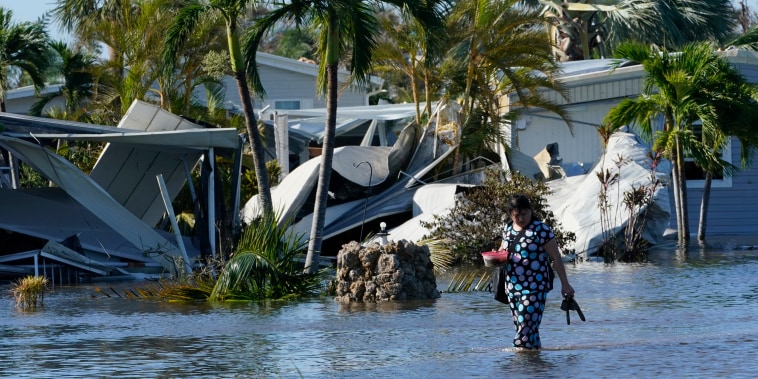 Holly Nugyn recorre su vencindario inudnado el 29 de septiembre de 2022 tras el paso del huracán Ian en Fort Myers, Florida.