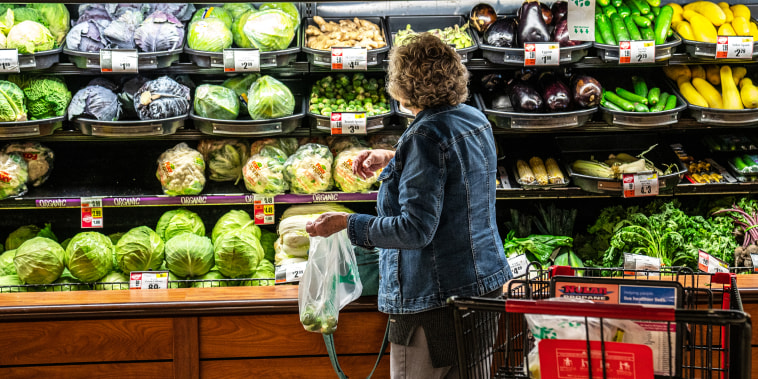A woman selects fresh vegetables at a Tops Super Market on Oct. 27, 2022 in Greenville, N.Y.