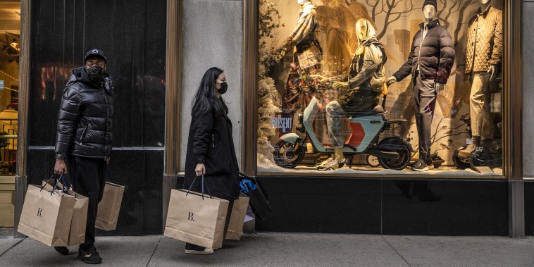 Shoppers walk past a Bergdorf Goodman store on Fifth Avenue in New York on Dec. 27, 2021.