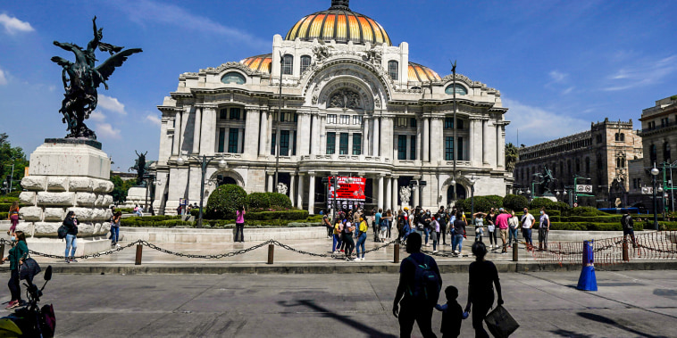 People walk outside the Palacio de Bellas Artes, Fine Arts Palace, in downtown Mexico City Oct. 2021. 