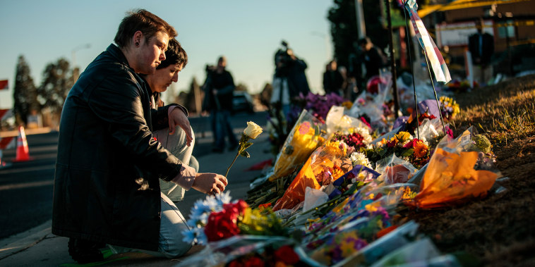 Ren Kurgis, left and Jessie Pacheco leave flowers at the growing memorial at the scene, related to the shooting inside Club Q last night on Nov. 20, 2022 in Colorado Springs, Colo.