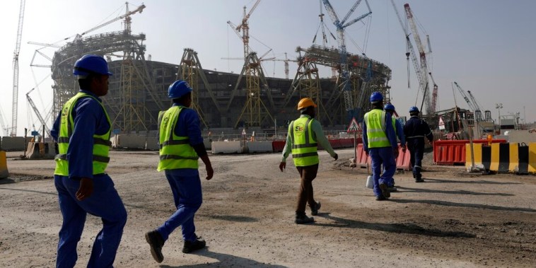 Un grupo de trabajadores migrantes frente a un estadio en construcción para el Mundial de Catar, en una imagen de archivo tomada el 20 de diciembre de 2019.