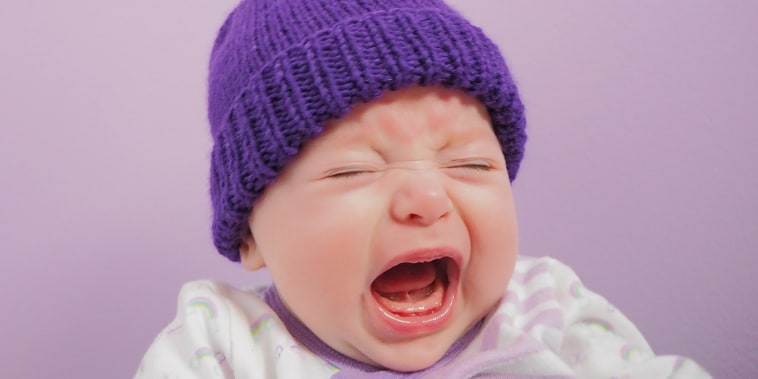 Close-Up Of Crying Baby Against Purple Background