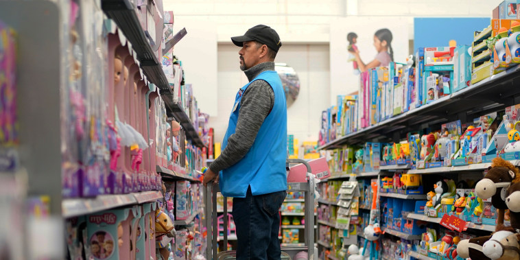 An employee stocks shelves in the toy section of a Walmart