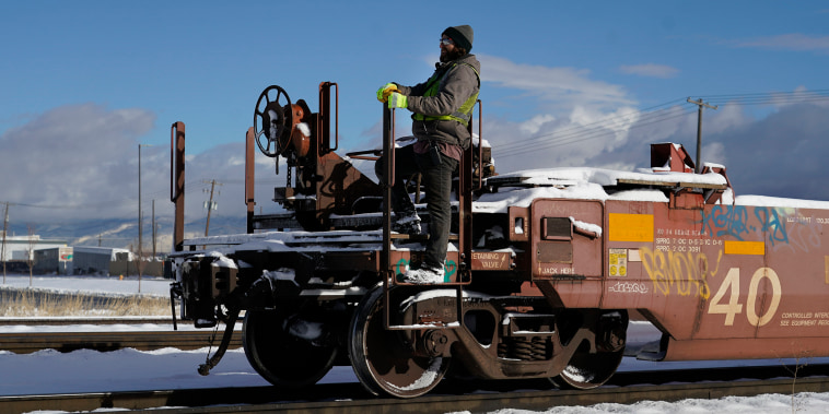 A worker climbs onto a railcar at the Union Pacific Intermodal rail terminal in Salt Lake City, Utah, on Dec. 2, 2022. 