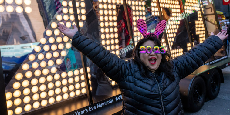 Teresa Hui, wearing 2023 glasses, poses in front of the “2023” numerals after the illumination ceremony in Times Square 