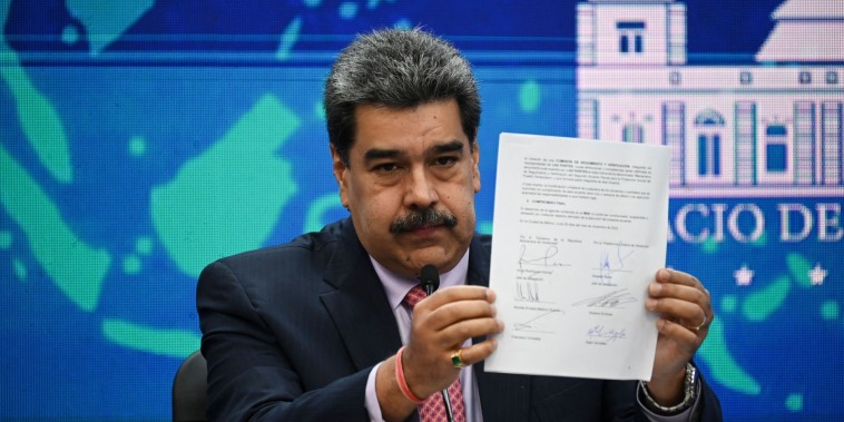 Nicolás Maduro sostiene una copia de un acuerdo humanitario, firmado el 26 de noviembre por representantes del régimen y de la oposición venezolanas, durante una conferencia de prensa el 30 de noviembre.