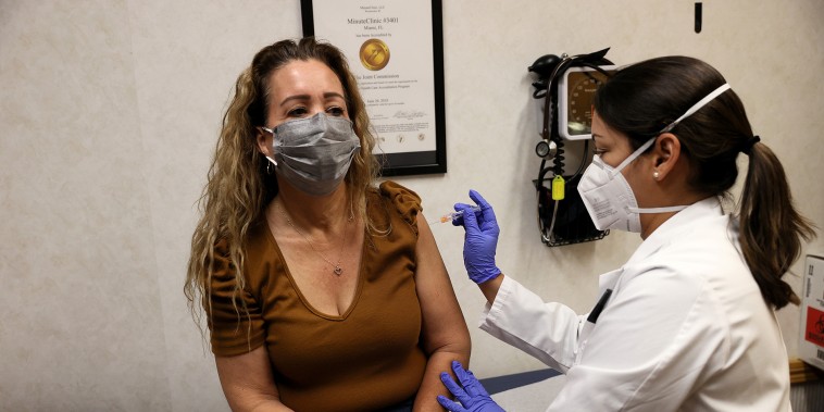 Susana Sánchez, una enfermera profesional, administra una vacuna contra la gripe a Loisy Barrera en una farmacia CVS y MinuteClinic el 10 de septiembre de 2021 en Miami, Florida.