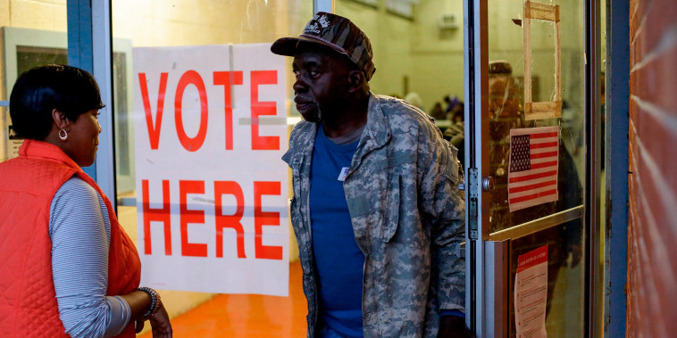 Voters exit a polling station at the National Guard Military Base during the presidential primary in Camden, Ala.,