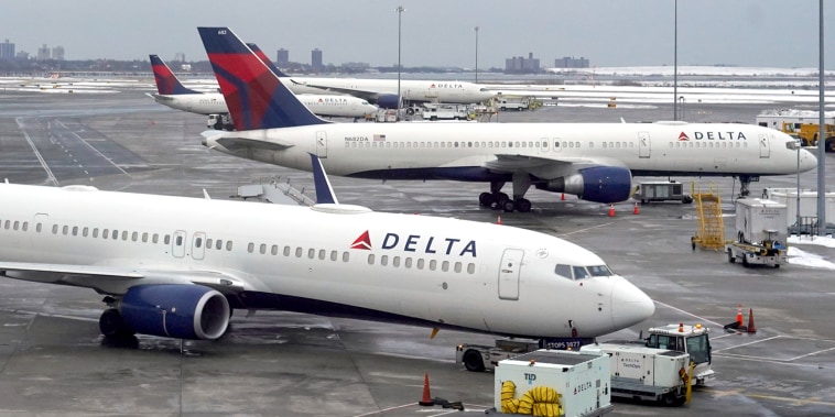 Delta Airlines plans parked at Terminal 4 at a snow-covered John F. Kennedy International Airport, Sunday, Feb. 14, 2021, in New York.