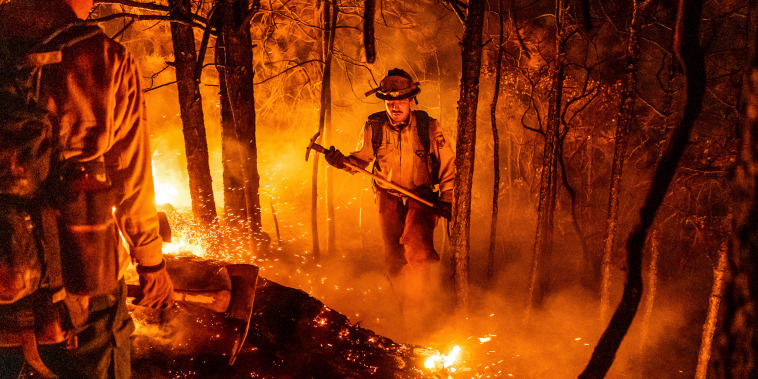 Firefighter Christian Mendoza manages a backfire, flames lit by firefighters to burn off vegetation, while battling the Mosquito Fire in Placer County, Calif., on Sept. 13, 2022.