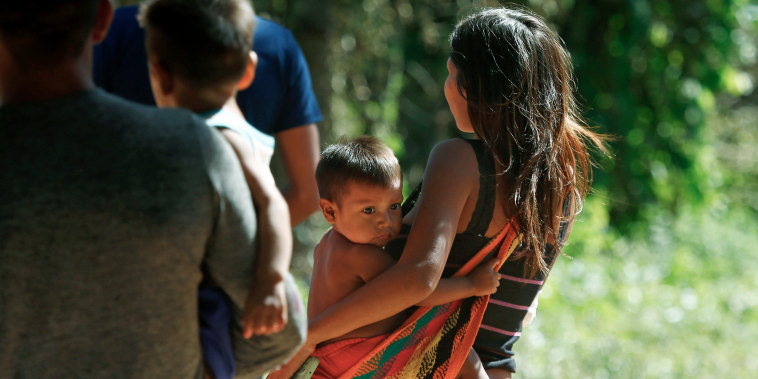 A Yanomami woman carries a toddler on the property of the Saude Indigenous House, a center responsible for supporting and assisting Indigenous people in Boa Vista, Brazil, on Jan. 25, 2023. 