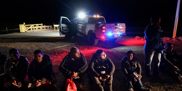 Migrantes esperan en la frontera a que los procesen los agentes de CBP, en Yuma, Arizona, el 6 de enero de 2023.