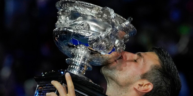 Novak Djokovic besa el trofeo de campeón del Abierto de Australia tras derrotar a Stefanos Tsitsipas en la final, este domingo 29 de enero en Melbourne.