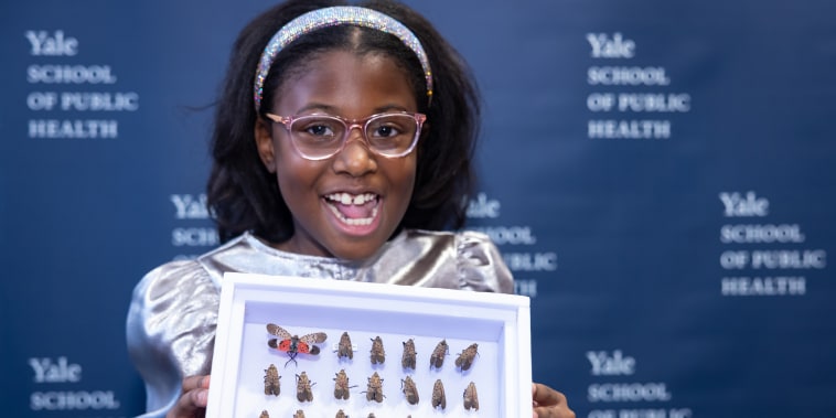 Bobbi Wilson holds up her collection of spotted lanternflies as she was honored at the Yale School of Public Health for her efforts in eradicating the invasive species in her hometown of Caldwell, N.J.
