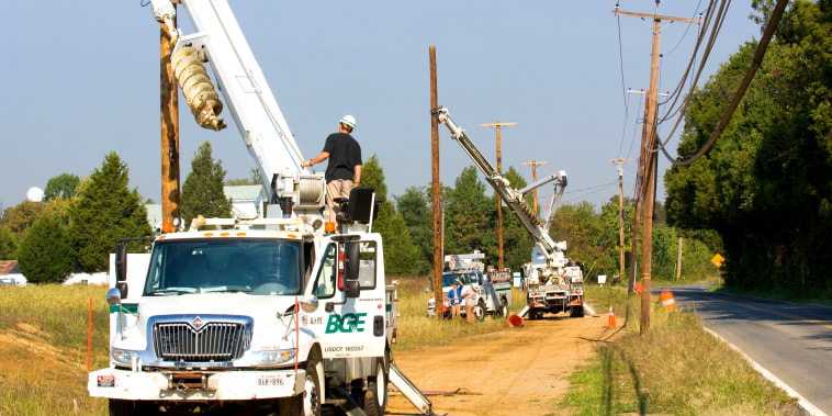 Baltimore Gas & Electric trucks hooking up power lines
