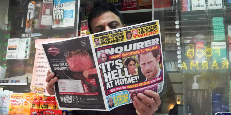 A newspaper vendor displays a copy of the National Enquirer at his newstand in New York