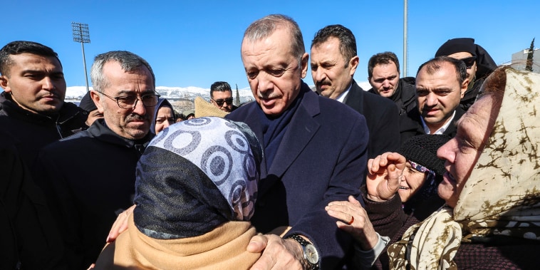 Image: Turkey's President Recep Tayyip Erdogan and a survivor speak as he visits the city center destroyed by Monday earthquake in Kahramanmaras, southern Turkey, on Feb. 8, 2023. 