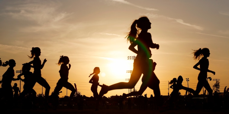 Runners compete in a 5k at sunset.