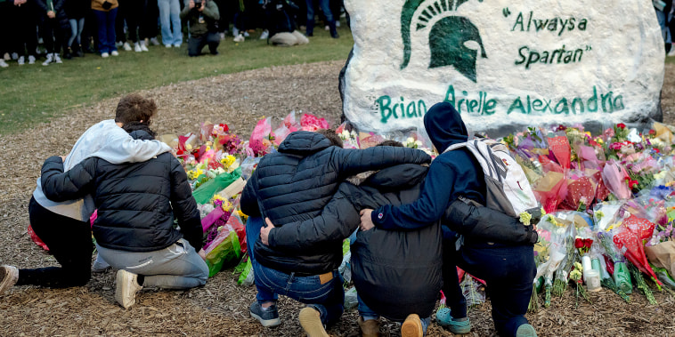 People embrace during the vigil at The Rock on Michigan State Universitys campus in East Lansing, Michigan on February 15, 2023.